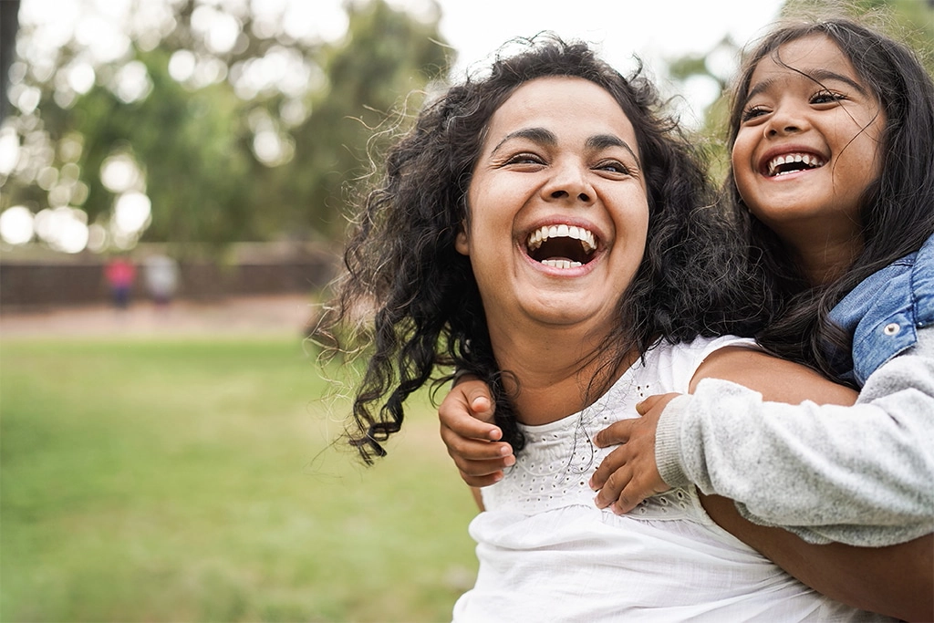 Mom Carrying Her Daughter Through A Park In South Jersey